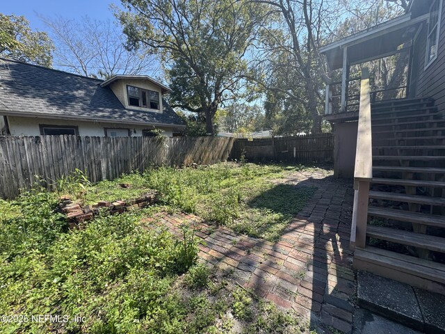 view of yard featuring a fenced backyard and stairway