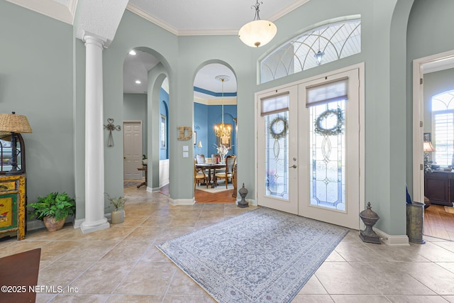 tiled foyer entrance with ornate columns, baseboards, ornamental molding, and french doors