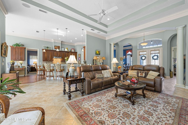 living room featuring ornamental molding, arched walkways, visible vents, and decorative columns