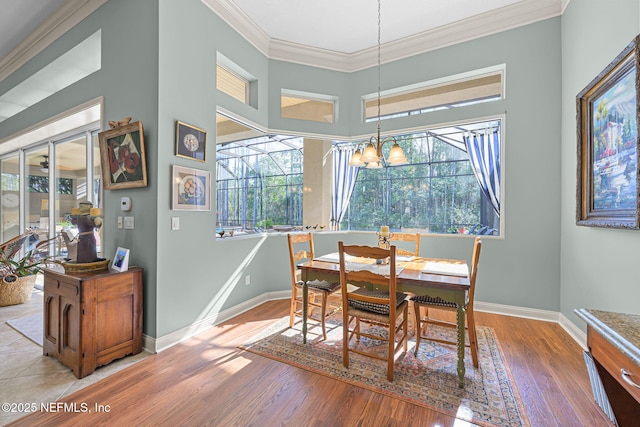 dining area featuring ornamental molding, baseboards, and wood finished floors