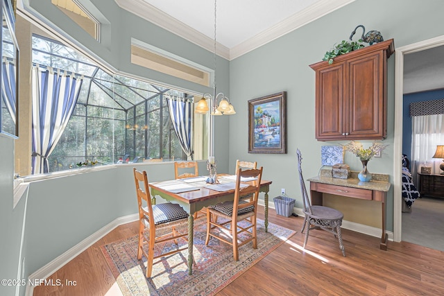 dining space with baseboards, wood finished floors, and crown molding