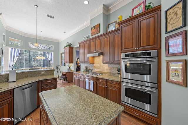 kitchen featuring dark wood-style floors, stainless steel appliances, decorative backsplash, and under cabinet range hood