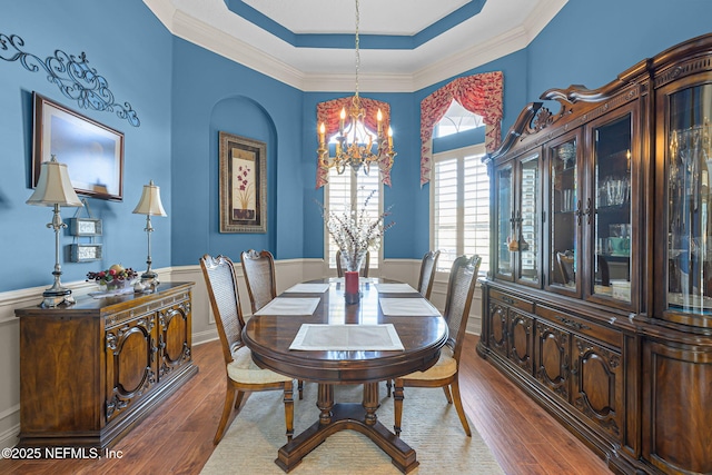 dining room featuring wainscoting, wood finished floors, and a notable chandelier