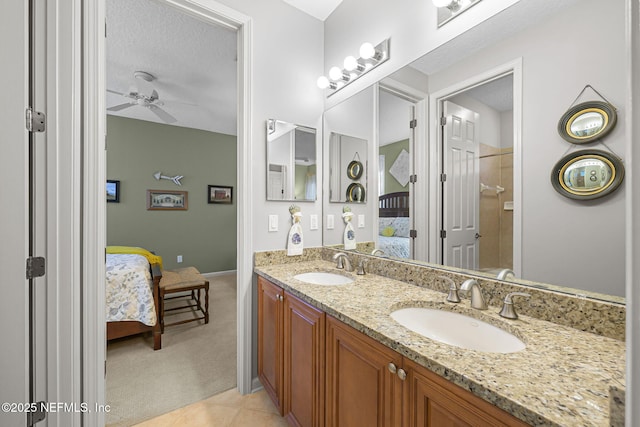 ensuite bathroom featuring a sink, double vanity, ceiling fan, and connected bathroom