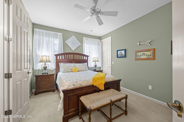 bedroom with light carpet, a closet, baseboards, and a textured ceiling