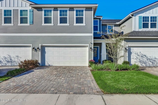454 Pine Bluff Dr, Saint Augustine, FL 32092 - view of front of property featuring board and batten siding, decorative driveway, and an attached garage