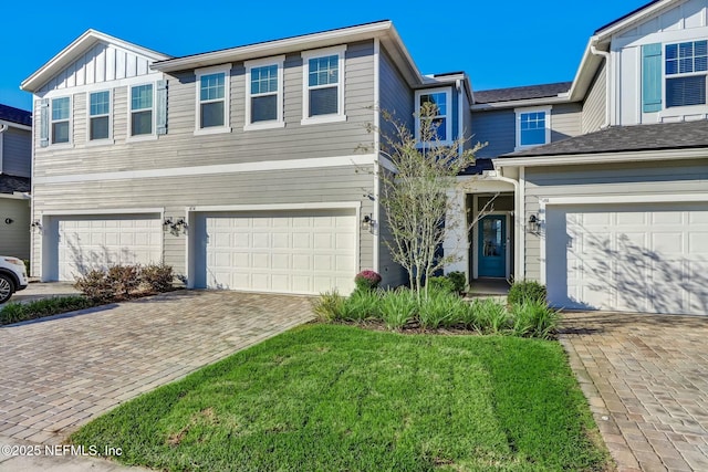 454 Pine Bluff Dr, Saint Augustine, FL 32092 - view of front of house with an attached garage, driveway, board and batten siding, and a front yard