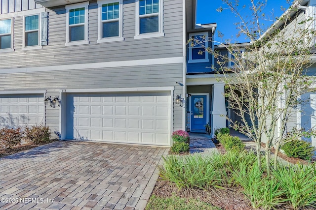 454 Pine Bluff Dr, Saint Augustine, FL 32092 - view of front of house featuring a garage, decorative driveway, and board and batten siding