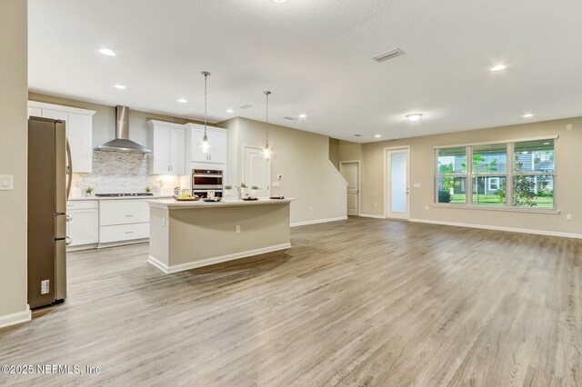 454 Pine Bluff Dr, Saint Augustine, FL 32092 - kitchen featuring pendant lighting, appliances with stainless steel finishes, open floor plan, wall chimney range hood, and an island with sink