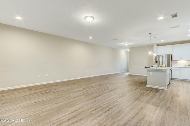454 Pine Bluff Dr, Saint Augustine, FL 32092 - kitchen featuring open floor plan, light countertops, a center island, stainless steel fridge, and decorative light fixtures