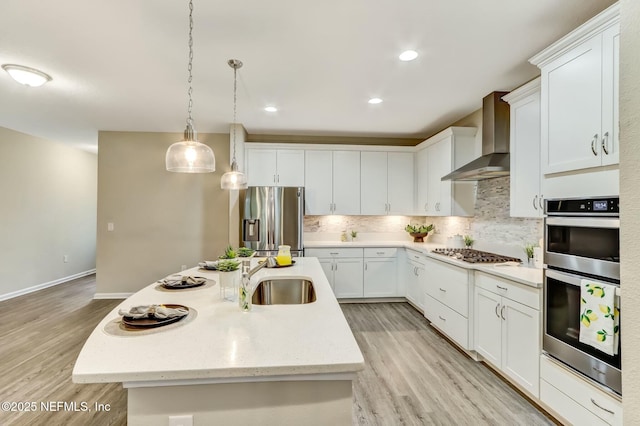 454 Pine Bluff Dr, Saint Augustine, FL 32092 - kitchen with a center island with sink, stainless steel appliances, white cabinetry, a sink, and wall chimney range hood