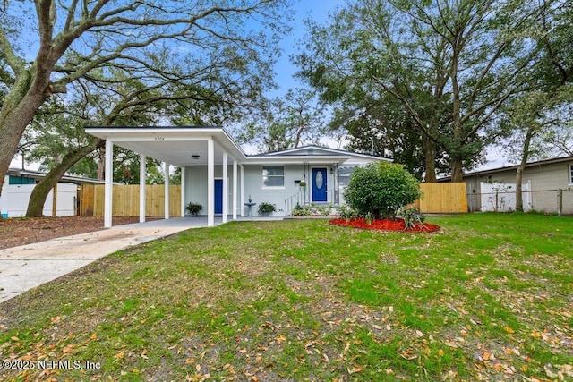 view of front of house with concrete driveway, an attached carport, a front yard, and fence