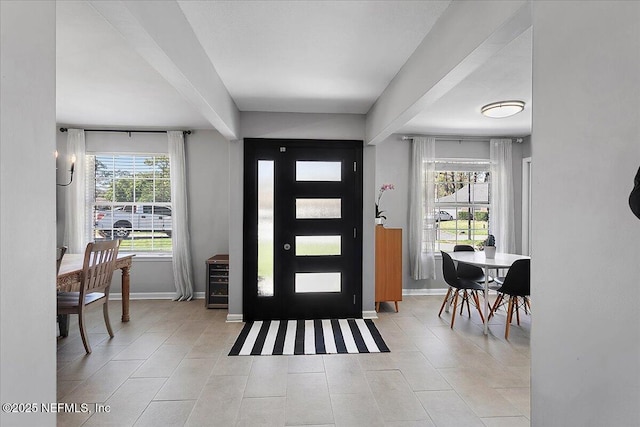 tiled foyer featuring baseboards