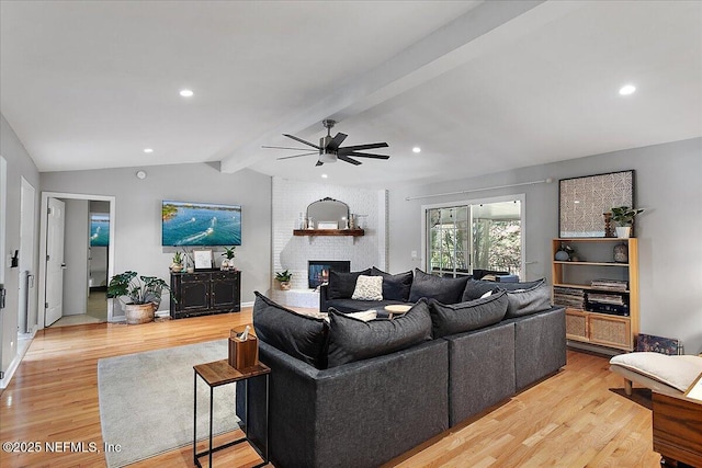 living room with a brick fireplace, baseboards, lofted ceiling with beams, recessed lighting, and light wood-style flooring