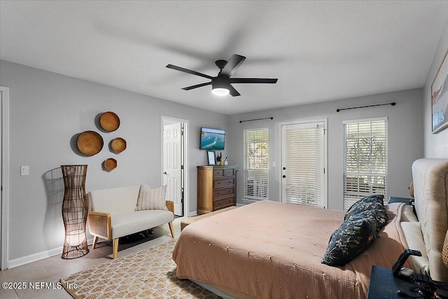 bedroom with tile patterned flooring, multiple windows, baseboards, and access to exterior