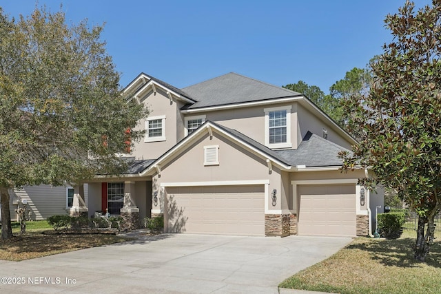 traditional home featuring concrete driveway, stone siding, roof with shingles, an attached garage, and stucco siding