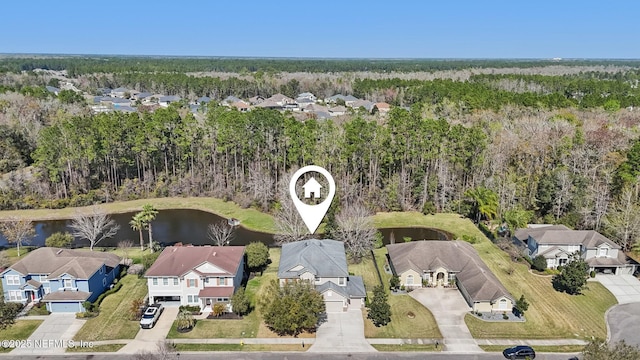 aerial view with a residential view, a water view, and a view of trees