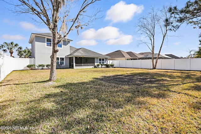 back of house with a sunroom, a fenced backyard, and a lawn