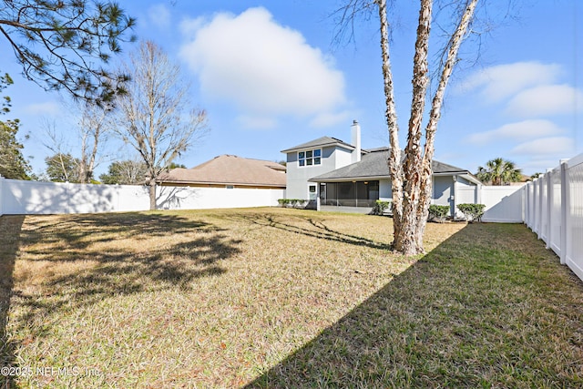 view of yard featuring a sunroom and a fenced backyard