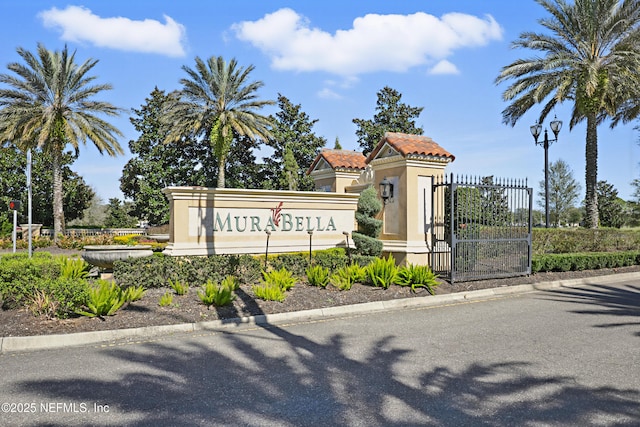 community sign featuring fence and a gate