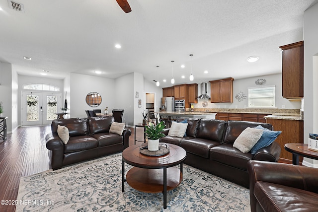 living room with french doors, recessed lighting, visible vents, wood finished floors, and baseboards