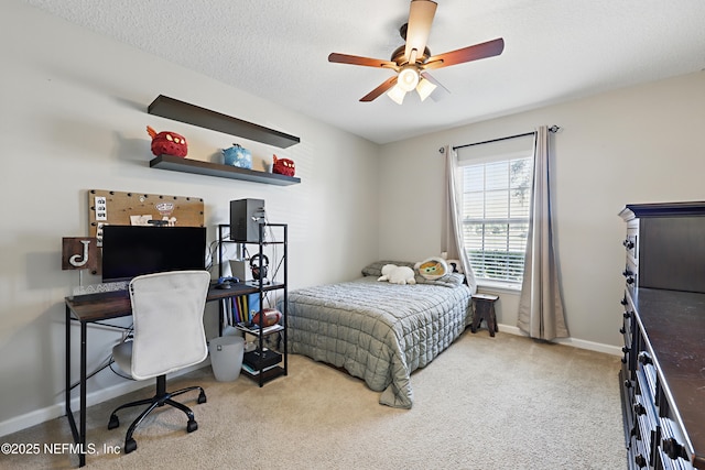 carpeted bedroom featuring ceiling fan, a textured ceiling, and baseboards