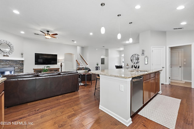 kitchen with visible vents, dark wood finished floors, open floor plan, a fireplace, and a sink