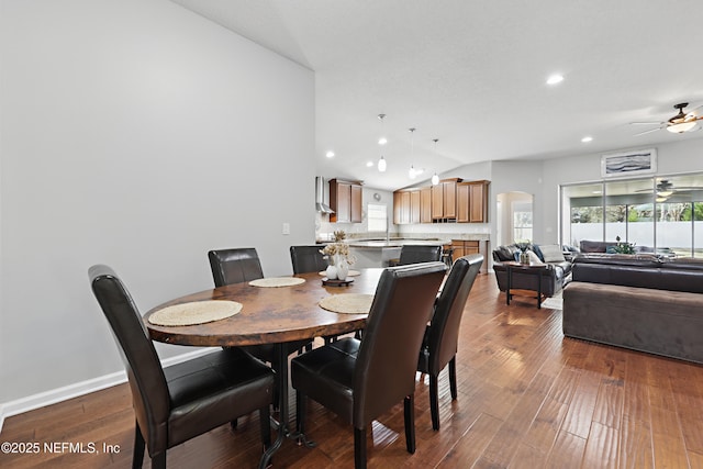 dining area featuring arched walkways, dark wood finished floors, lofted ceiling, recessed lighting, and ceiling fan