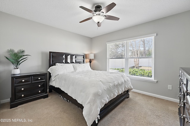 bedroom with light carpet, ceiling fan, a textured ceiling, and baseboards