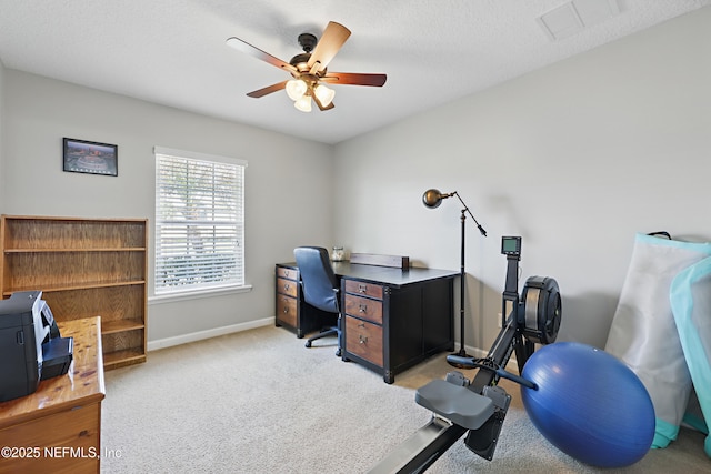 carpeted home office featuring baseboards, a textured ceiling, visible vents, and a ceiling fan