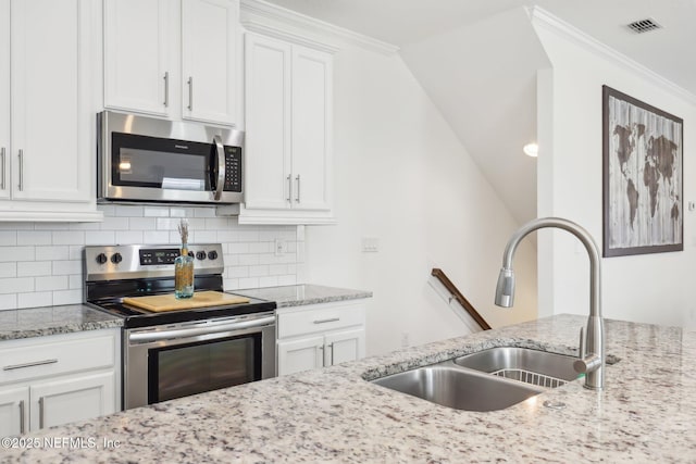 342 4th St N, Jacksonville Beach, FL 32250 - kitchen with crown molding, tasteful backsplash, appliances with stainless steel finishes, white cabinets, and a sink