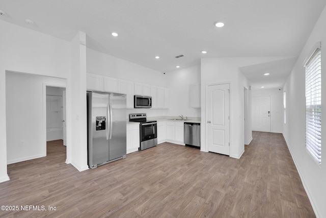 kitchen with light wood-style flooring, recessed lighting, stainless steel appliances, white cabinetry, and light countertops