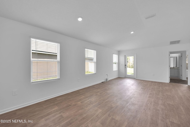 unfurnished living room with recessed lighting, wood finished floors, visible vents, and baseboards