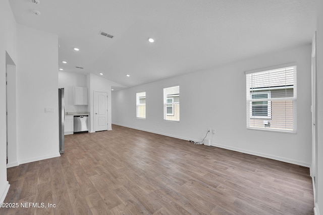 unfurnished living room featuring light wood finished floors, baseboards, visible vents, vaulted ceiling, and recessed lighting