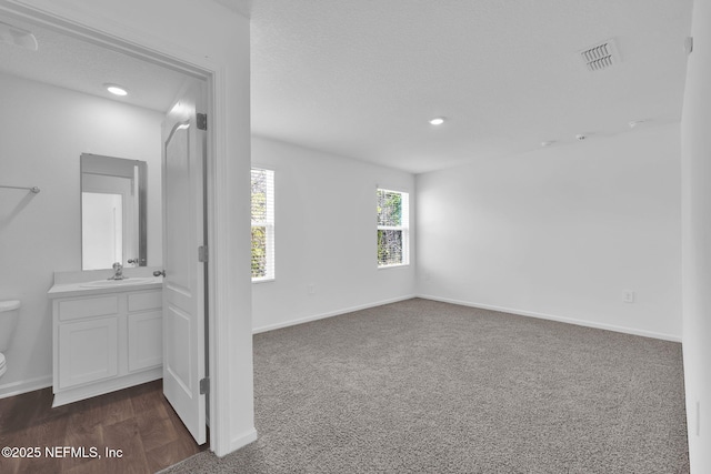 spare room featuring visible vents, a sink, and baseboards