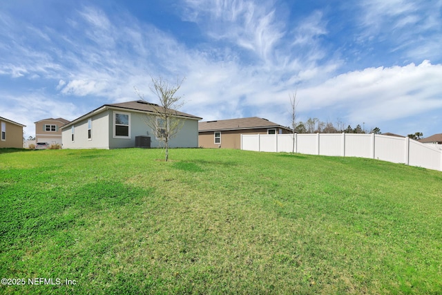 view of yard featuring fence and central AC unit