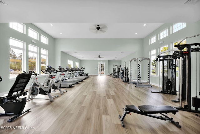 gym featuring light wood-type flooring, a high ceiling, baseboards, and recessed lighting