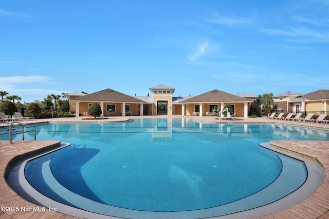 community pool with a patio and fence