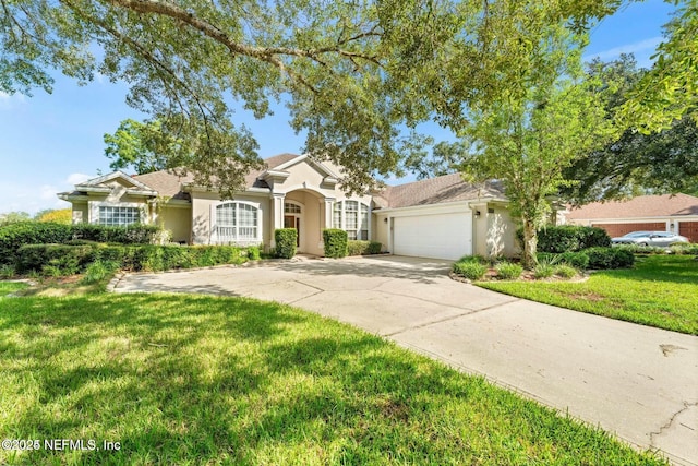 mediterranean / spanish-style house with a garage, driveway, a front lawn, and stucco siding