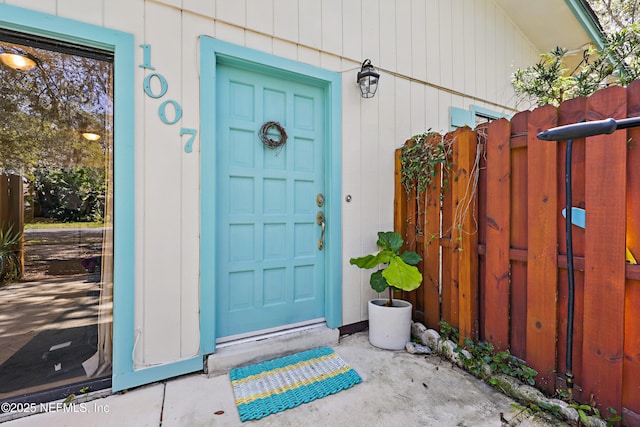 view of exterior entry featuring fence