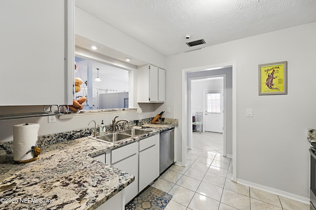 kitchen featuring visible vents, stainless steel dishwasher, white cabinets, a sink, and a textured ceiling