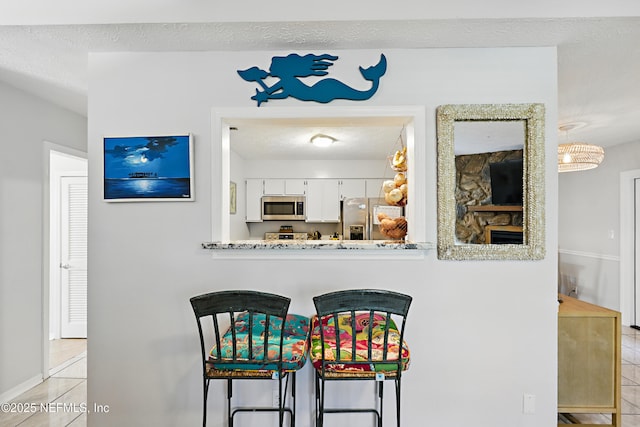 dining area with a textured ceiling and light tile patterned floors