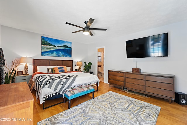 bedroom with connected bathroom, ceiling fan, and wood finished floors