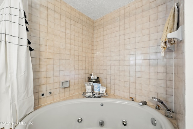 full bathroom with a whirlpool tub, tile walls, and a textured ceiling