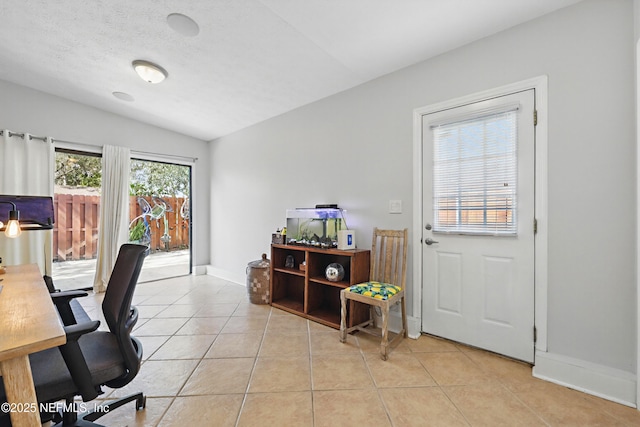 office area featuring baseboards, vaulted ceiling, a textured ceiling, and light tile patterned flooring