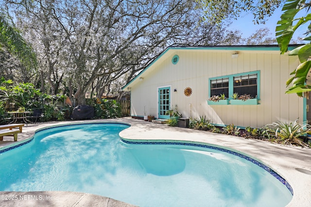 outdoor pool with a patio area and fence