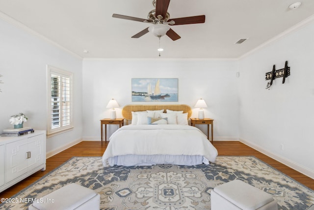 bedroom featuring baseboards, visible vents, and wood finished floors