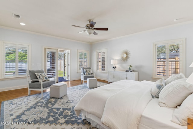 bedroom with baseboards, wood finished floors, visible vents, and access to exterior