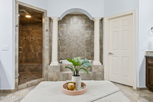 bathroom featuring decorative columns, a shower stall, vanity, and tile patterned floors