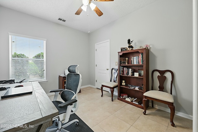 home office featuring baseboards, visible vents, ceiling fan, a textured ceiling, and light tile patterned flooring